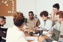 A group of people in a board room meeting working