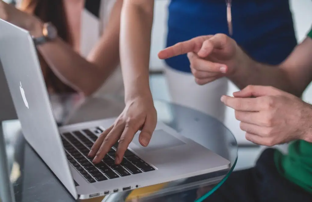 person touching and pointing MacBook Pro