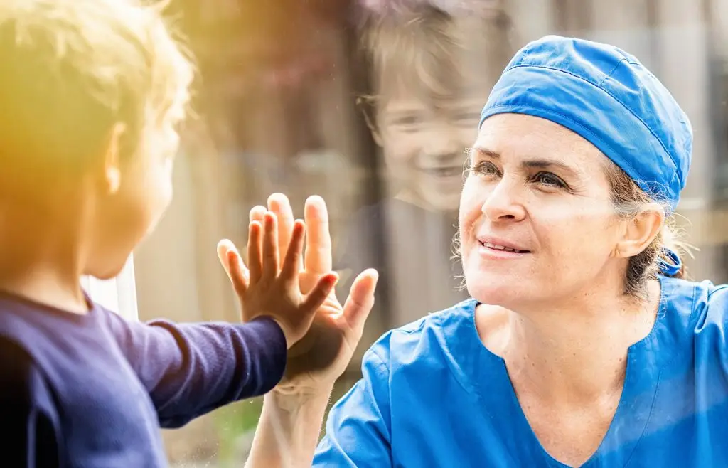 Woman and child pressing hands up against a window