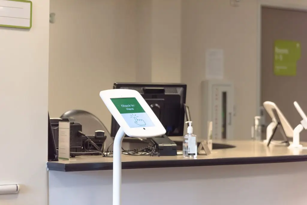 Check-in kiosk tablet upon arrival at front desk of test center for diagnostic testing, medical.