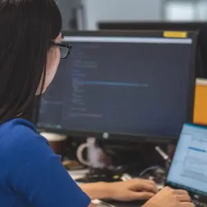 Woman sitting at desk typing on laptop